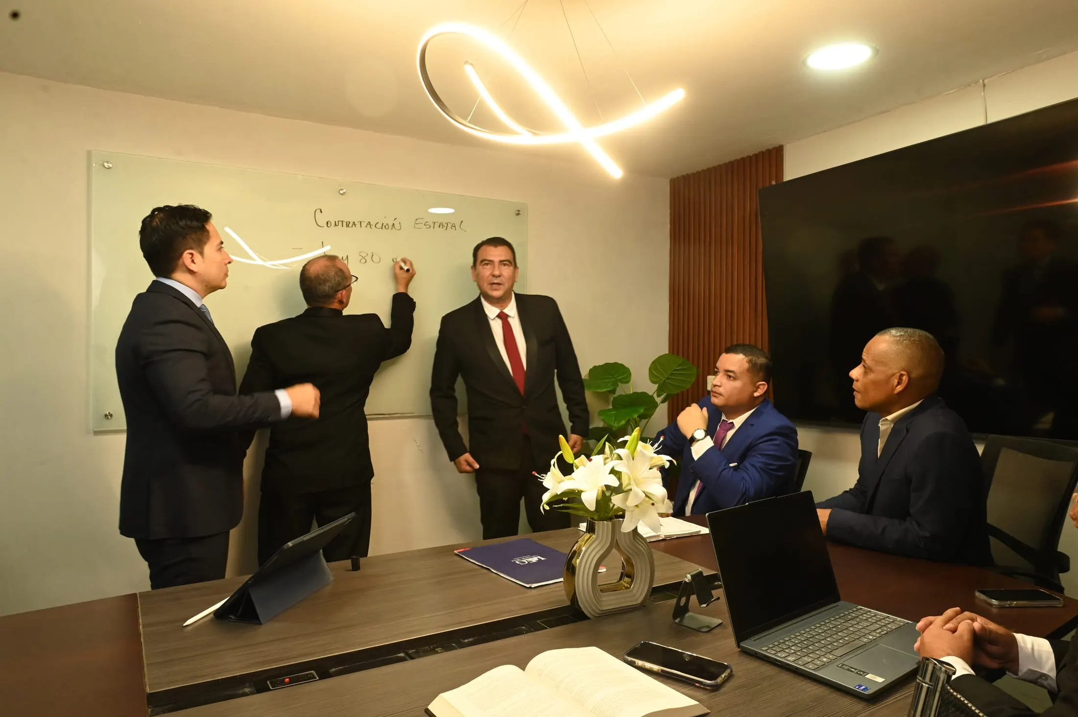Equipo de la firma analizando un caso frente a la pizarra